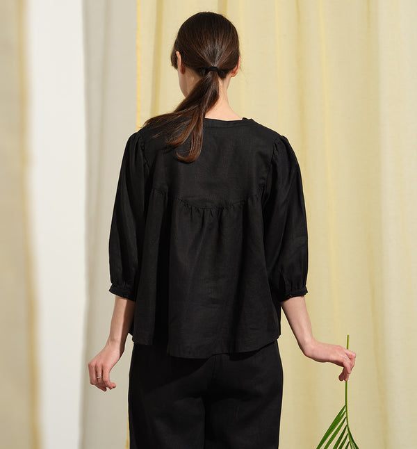 Liebling blus Lynn är en smula countryinspirerad i modellen. V-ringad, puffiga ärmar och rundat ok bak. Armbågslång ärm med smal manschett med en knapp. Svarta knappar mitt fram.

Färg: Svart

Material: 100% lin

Materialursprung:&nbsp;Detta tyg är ett deadstock tyg och kommer från Italien.&nbsp;