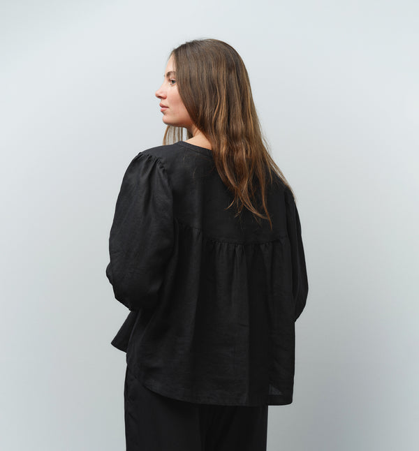 Liebling blus Lynn är en smula countryinspirerad i modellen. V-ringad, puffiga ärmar och rundat ok bak. Armbågslång ärm med smal manschett med en knapp. Svarta knappar mitt fram.

Färg: Svart

Material: 100% lin

Materialursprung: Detta tyg är ett deadstock tyg och kommer från Italien.