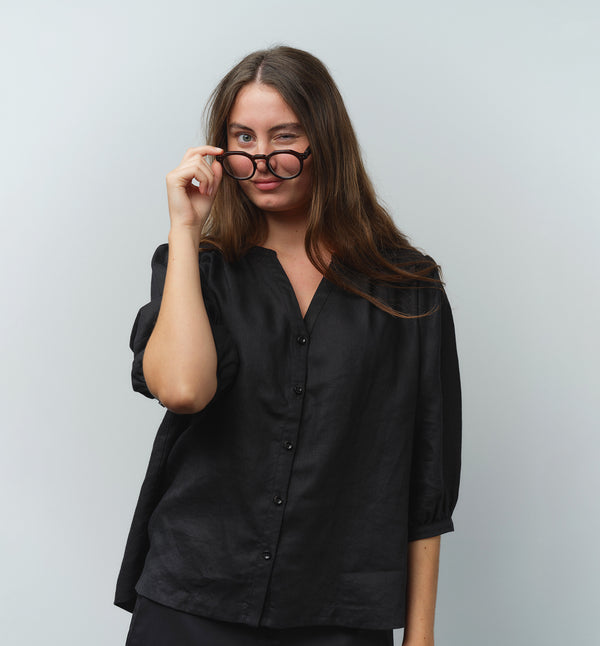 Liebling blus Lynn är en smula countryinspirerad i modellen. V-ringad, puffiga ärmar och rundat ok bak. Armbågslång ärm med smal manschett med en knapp. Svarta knappar mitt fram.

Färg: Svart

Material: 100% lin

Materialursprung: Detta tyg är ett deadstock tyg och kommer från Italien.