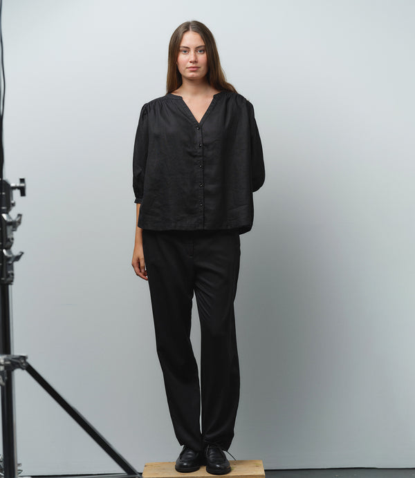 Liebling blus Lynn är en smula countryinspirerad i modellen. V-ringad, puffiga ärmar och rundat ok bak. Armbågslång ärm med smal manschett med en knapp. Svarta knappar mitt fram.

Färg: Svart

Material: 100% lin

Materialursprung: Detta tyg är ett deadstock tyg och kommer från Italien.