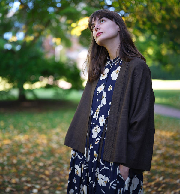  klänning Lyra. Murarkrage med avtagbart band. Knappslå fram med mörkblå knappar. Söm och rynk i midjan. Fickor i sidorna. Bandet knäpps på översta knappen. En fin detalj som ger Lyra fler stylingsmöjligheter. Sydd i en ekologisk viskos. Bandet ingår.

Färg: Gräddvita blommor med gula och olivgröna detaljer på mörkblå botten.

Material:&nbsp;51% EcoVero, 49% viskos från Frankrike. 