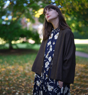  klänning Lyra. Murarkrage med avtagbart band. Knappslå fram med mörkblå knappar. Söm och rynk i midjan. Fickor i sidorna. Bandet knäpps på översta knappen. En fin detalj som ger Lyra fler stylingsmöjligheter. Sydd i en ekologisk viskos. Bandet ingår.

Färg: Gräddvita blommor med gula och olivgröna detaljer på mörkblå botten.

Material:&nbsp;51% EcoVero, 49% viskos från Frankrike. 