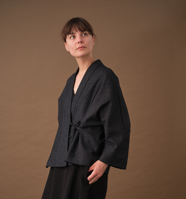 Lieblings fina kimono Margot i rak modell med omlottknyt. Lite längre bak än fram. Margot Stenhimlar är sydd i en stadig ullblandning. Tyget är ett deadstocktyg.

Färg: Svart med vita rutor

Material: 48% ull, 39% polyamid, 13% bomull