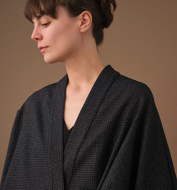 Lieblings fina kimono Margot i rak modell med omlottknyt. Lite längre bak än fram. Margot Stenhimlar är sydd i en stadig ullblandning. Tyget är ett deadstocktyg.

Färg: Svart med vita rutor

Material: 48% ull, 39% polyamid, 13% bomull