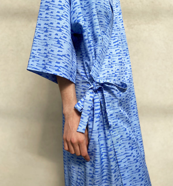 Kimonoklänning Mika i rak modell med omlottknyt och fickor i sidorna. Fin både som klänning och lång kimono.  Färg: Blå med våg- och bergmönster i mörkare blå. Material:  100% Lyocell