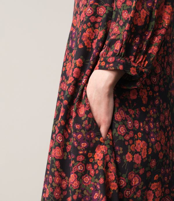 Vår klänning Nea! V-ringad, söm i midjan, trekvarts ärm med smal manschett och knapp, fickor i sidorna.&nbsp;&nbsp;

Färg: Blommor i roströda, mörklila, gröna och orangea toner på svart botten.

Material: 51% EcoVero, 49% viskos från Frankrike.