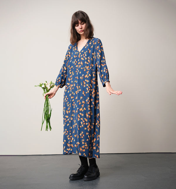 Vår klänning Nea Paradiso! V-ringad, söm i midjan, trekvarts ärm med smal manschett och fickor i sidorna.&nbsp;&nbsp;

Färg: Blommor i gula, beiga och gröna toner på blå botten.

Material: 51% EcoVero, 49% viskos från Frankrike.