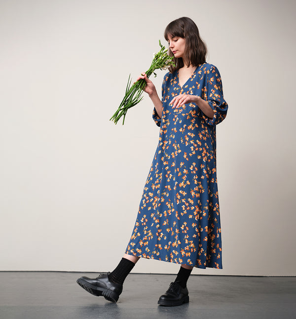 Vår klänning Nea Paradiso! V-ringad, söm i midjan, trekvarts ärm med smal manschett och fickor i sidorna.&nbsp;&nbsp;

Färg: Blommor i gula, beiga och gröna toner på blå botten.

Material: 51% EcoVero, 49% viskos från Frankrike.