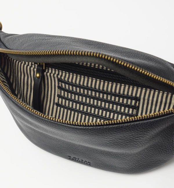 Möt Niko, O My Bags nyaste bum bag! Tillverkad av smidigt mjukt narvläder. Niko har en säker dragkedja, ett rymligt huvudfack, en innerficka med dragkedja, inbyggda kortfack, mässingsdetaljer och en justerbar randig rem. Smart förvaring, enkel styling, inget behov av att gräva i fickorna. Färg: svart med axelband i svart/offwhite