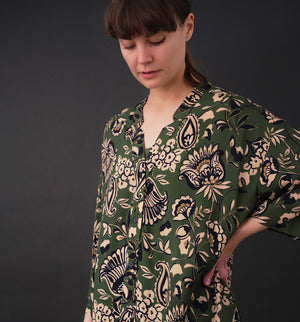 klänning Naja Lotus. En ankellång klänning med fina kragdetaljer. Ok med veck i ryggen, fickor i sidorna. Naja är fin både öppen och stängd. Små svarta knappar mitt fram. Sydd i en ekologisk viskos.

Färg: Blommor i beige, svart och gulgrönt på grön botten.

Material:&nbsp;51% EcoVero, 49% viskos från Frankrike.