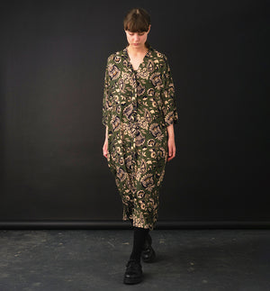 klänning Naja Lotus. En ankellång klänning med fina kragdetaljer. Ok med veck i ryggen, fickor i sidorna. Naja är fin både öppen och stängd. Små svarta knappar mitt fram. Sydd i en ekologisk viskos.

Färg: Blommor i beige, svart och gulgrönt på grön botten.

Material:&nbsp;51% EcoVero, 49% viskos från Frankrike.