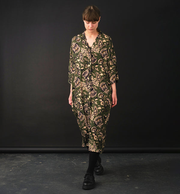 klänning Naja Lotus. En ankellång klänning med fina kragdetaljer. Ok med veck i ryggen, fickor i sidorna. Naja är fin både öppen och stängd. Små svarta knappar mitt fram. Sydd i en ekologisk viskos.

Färg: Blommor i beige, svart och gulgrönt på grön botten.

Material:&nbsp;51% EcoVero, 49% viskos från Frankrike.