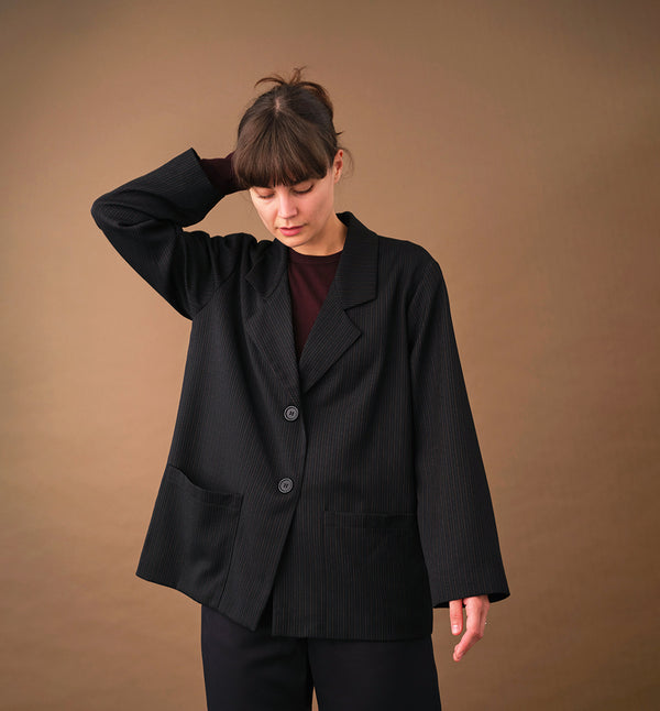 kavaj Sonia Kritstreck. En avslappnad kavaj. Helfodrad och fickor fram. Sydd i ett deadstock tyg.

Färg: Svart med grå och roströda streck, svart foder.

Material: Yttertyg: 100% ull, deadstock. Foder: 60% acetat, 40% viskos från Italien.