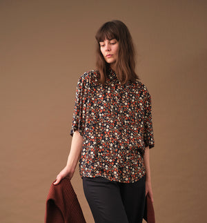 Lieblings skjorta Unni. Unni är en vid skjorta med armbågslång ärm. Ok med veck i ryggen. Lätt rundad bak. Sydd i en ekologisk viskos.

Färg: Små blommor i beige, vitt och orange på svart botten. Svart band.

Material:&nbsp;51% EcoVero, 49% viskos från Frankrike.