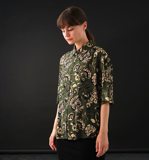 skjorta Unni. Unni är en vid skjorta med armbågslång ärm. Ok med veck i ryggen. Lätt rundad bak. Sydd i en ekologisk viskos.

Färg: Blommor i beige, svart och gulgrönt på grön botten.

Material:&nbsp;51% EcoVero, 49% viskos från Frankrike. 