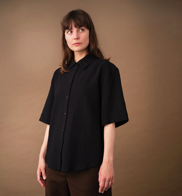 skjorta Unni. Unni är en vid skjorta med armbågslång ärm. Ok med veck i ryggen. Lätt rundad bak. Sydd i en ekologisk viskos.

Färg: Svart

Material:&nbsp;98% bomull, 2% elastan. Tyget kommer från Portugal.