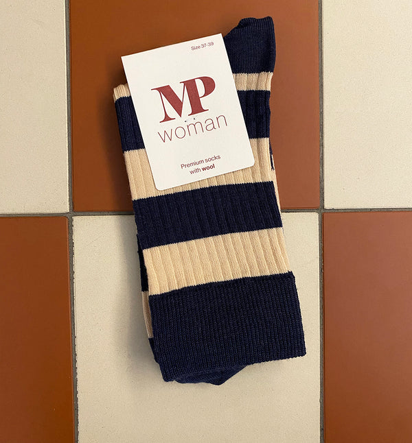 Mjuka ullstrumpor med ribbstruktur från MPwoman. Strumporna har breda horisontella ränder och en bred ribb upptill. Merinoull, en naturlig ullprodukt från merinofår, är känd för sina temperaturreglerande egenskaper som håller fötterna varma även i vått väder och förhindrar svettlukt. För att säkerställa bästa möjliga passform har strumporna en anatomiskt korrekt häl med 90° vinkel och en förstärkt häl och tå för ökad hållbarhet.

Färg: Mörkblå, naturvit

Material: 80% ull, 17% polyamid, 3% elastan.

Tillver
