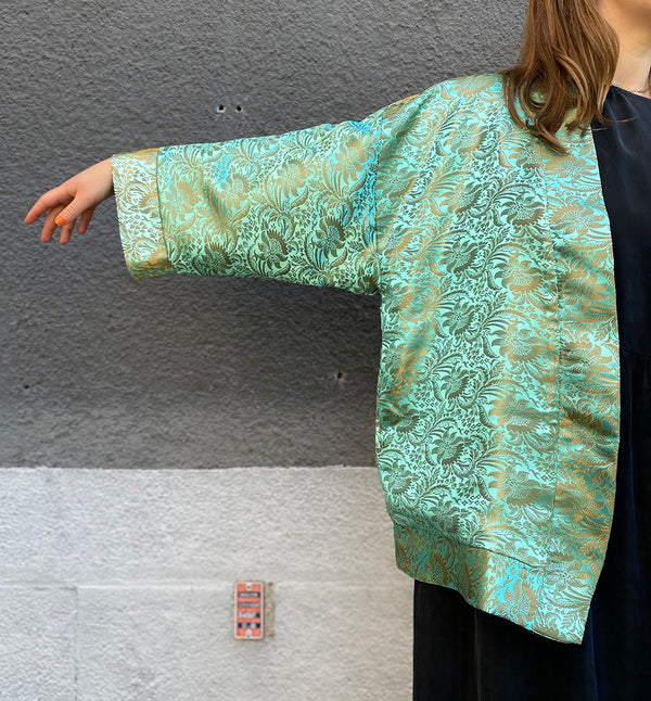I samarbete med REMAKE Skåne stadsmission har vi tagit fram denna lyxiga kimono. Kimonon är sydd i Remakes studio i Malmö av upcyklat material. Yttertyg i ett vackert mönster i mintgrönt och beiget.&nbsp;Kimonon är fodrad och har fickor i sidorna. One size.