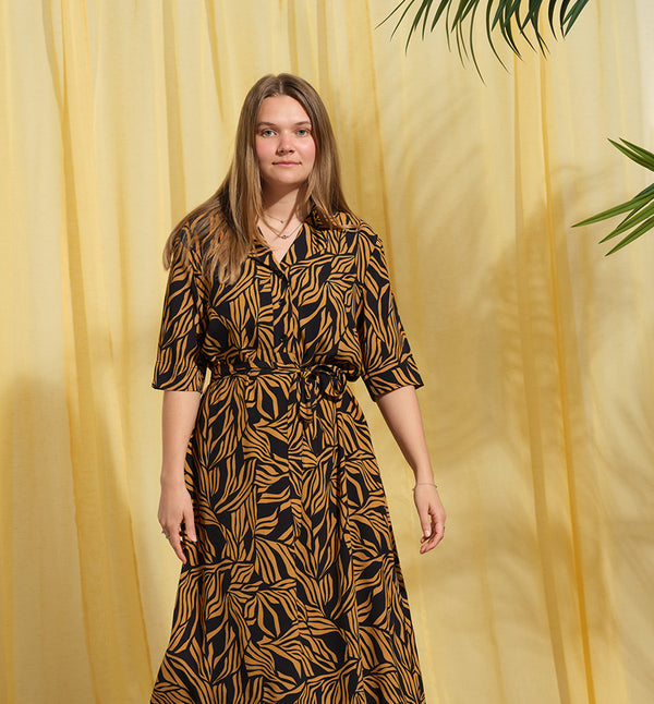 Lieblings  klänning Sally i tyget Cannes. Sally är en A-linjeformad klänning med krage, knappslå, ok med små veck i ryggen och fickor i sidorna. Band att knyta i midjan.&nbsp;

Färg: Ockragula palmblad på svart botten

Material: 51% EcoVero, 49% viskos från Frankrike. Tillverkad i:&nbsp;Litauen
Designad i:&nbsp;Malmö

Upplaga: 65 st