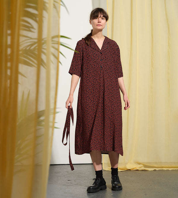 Liebling klänning Sally i tyget Rio. Sally är en A-linjeformad klänning med krage, knappslå, ok med små veck i ryggen och fickor i sidorna. Band att knyta i midjan.&nbsp;

Färg: Små röda blommor på svart botten

Material: 51% EcoVero, 49% viskos från Frankrike. 
Tillverkad i:&nbsp;Litauen
Designad i:&nbsp;Malmö