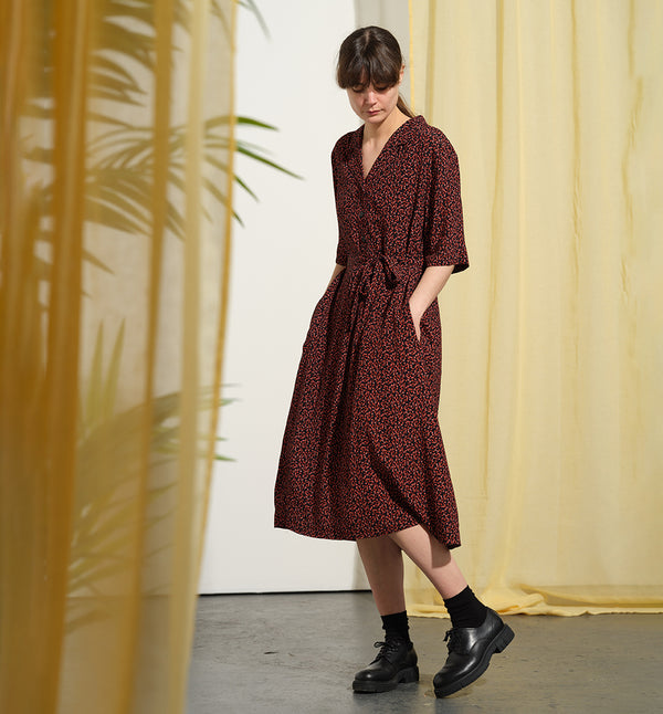 Liebling klänning Sally i tyget Rio. Sally är en A-linjeformad klänning med krage, knappslå, ok med små veck i ryggen och fickor i sidorna. Band att knyta i midjan.&nbsp;

Färg: Små röda blommor på svart botten

Material: 51% EcoVero, 49% viskos från Frankrike. 
Tillverkad i:&nbsp;Litauen
Designad i:&nbsp;Malmö