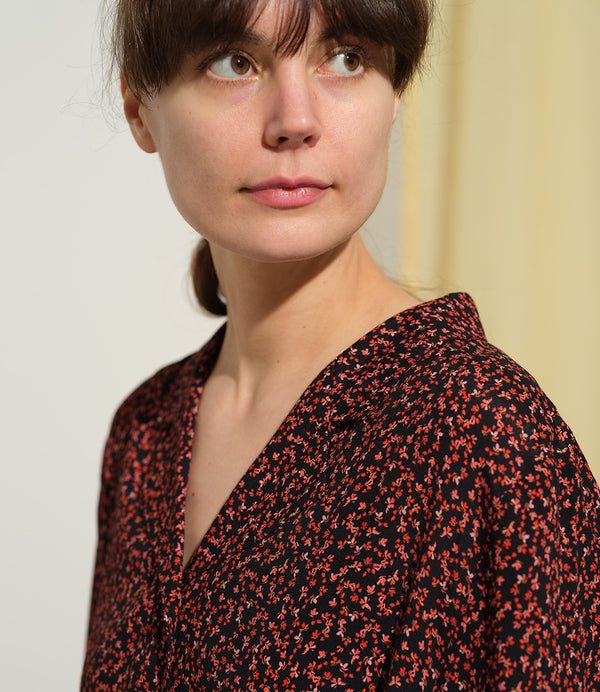 Liebling klänning Sally i tyget Rio. Sally är en A-linjeformad klänning med krage, knappslå, ok med små veck i ryggen och fickor i sidorna. Band att knyta i midjan.&nbsp;

Färg: Små röda blommor på svart botten

Material: 51% EcoVero, 49% viskos från Frankrike. 
Tillverkad i:&nbsp;Litauen
Designad i:&nbsp;Malmö