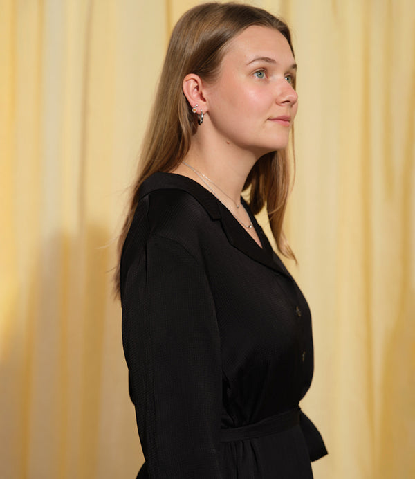 Liebling klänning Sally i tyget Zodiak. Sally är en A-linjeformad klänning med krage, knappslå, ok med små veck i ryggen och fickor i sidorna. Band att knyta i midjan. Tyget har en fin struktur som adderar det lilla extra!

Färg: Svart

Material: 100% viskos från Bulgarien.