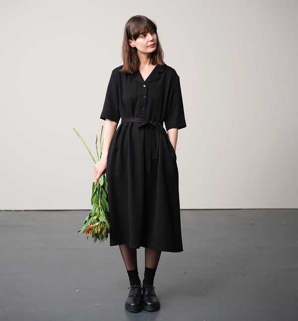Vår klänning Sally! Sally är A-linjeformad med krage, knappslå, ok med små veck i ryggen och fickor i sidorna. Band att knyta i midjan.&nbsp;

Färg: Svart

Material: 100% Lyocell.&nbsp;