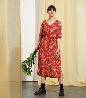 Lieblings klänning Sparv i tyget Kokos.&nbsp;Lyxigt enkel kaftanklänning till årets alla fester. Rak modell, v-ringning, sidfickor och slits i sidorna. Obibälte ingår.&nbsp;Bältet är&nbsp;lätt vadderat och passar även fint att ha till annat:)&nbsp;Sydd i en lyxig viskos med lite prickig struktur.&nbsp;

Färg: Blommor i klarrött, beige, cerise och bränd orange på roströd botten.

Material: 51% EcoVero, 49% viskos från Frankrike.