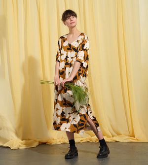 Liebling klänning Sparv i tyget Kokos.&nbsp;Lyxigt enkel kaftanklänning till årets alla fester. Rak modell, v-ringning, sidfickor och slits i sidorna. Obibälte ingår.&nbsp;Bältet är&nbsp;lätt vadderat och passar även fint att ha till annat:) Tyget är lite blankt vilket ger en extra lyxig känsla!&nbsp;

Färg: Vita blommor och svarta blad på guldbrun botten.

Material: 51% EcoVero, 49% viskos från Frankrike. 
Designad i Malmö, sydd i Litauen