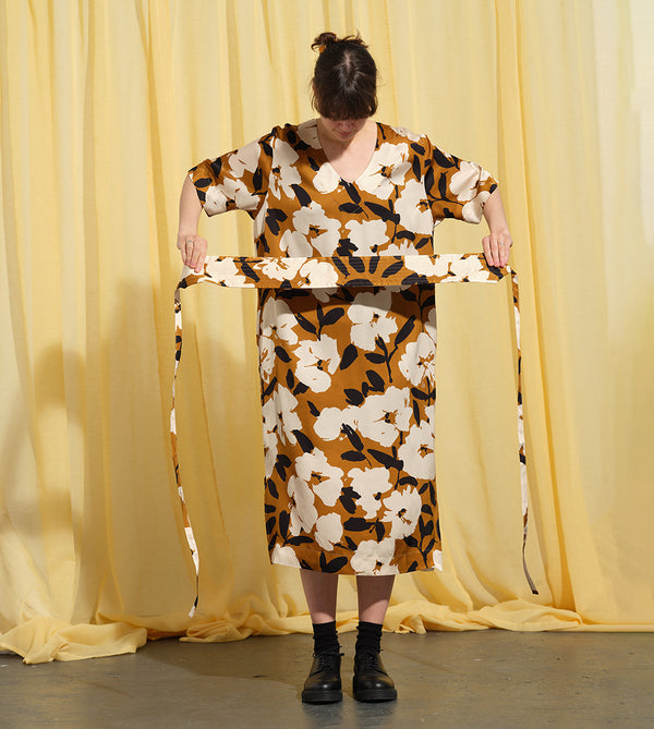 Liebling klänning Sparv i tyget Kokos.&nbsp;Lyxigt enkel kaftanklänning till årets alla fester. Rak modell, v-ringning, sidfickor och slits i sidorna. Obibälte ingår.&nbsp;Bältet är&nbsp;lätt vadderat och passar även fint att ha till annat:) Tyget är lite blankt vilket ger en extra lyxig känsla!&nbsp;

Färg: Vita blommor och svarta blad på guldbrun botten.

Material: 51% EcoVero, 49% viskos från Frankrike. 
Designad i Malmö, sydd i Litauen