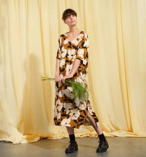 Liebling klänning Sparv i tyget Kokos.&nbsp;Lyxigt enkel kaftanklänning till årets alla fester. Rak modell, v-ringning, sidfickor och slits i sidorna. Obibälte ingår.&nbsp;Bältet är&nbsp;lätt vadderat och passar även fint att ha till annat:) Tyget är lite blankt vilket ger en extra lyxig känsla!&nbsp;

Färg: Vita blommor och svarta blad på guldbrun botten.

Material: 51% EcoVero, 49% viskos från Frankrike. 
Designad i Malmö, sydd i Litauen