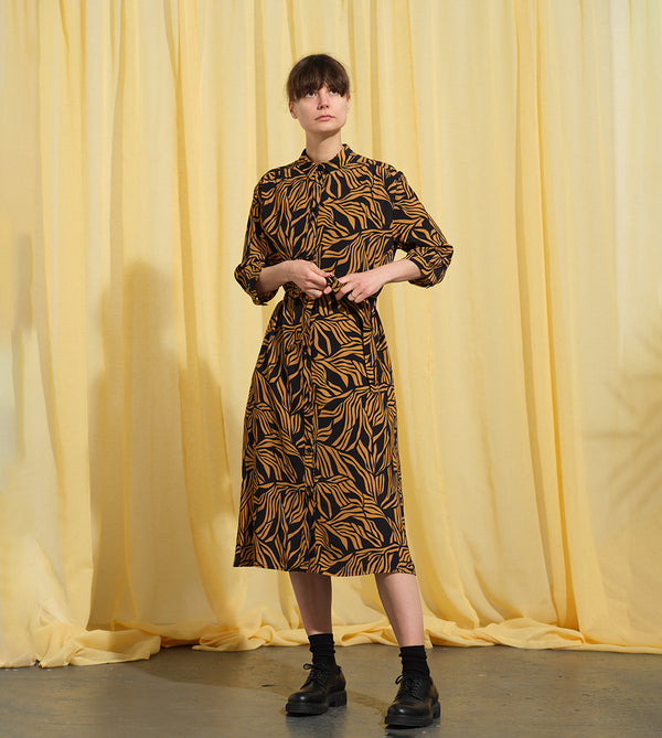 Lieblings klänning Svala Cannes. En vadlång skjortklänning med lös passform, trekvartsärm och fickor i sidorna. Ok med rynk i ryggen. Svala är fin både öppen och stängd, med eller utan band. Svarta knappar mitt fram och vid ärmslut. Sydd i en fin viskos.

Färg: Ockragula palmblad på svart botten

Material:&nbsp;51% EcoVero, 49% viskos från Frankrike.
Tillverkad i:&nbsp;Litauen
Designad i:&nbsp;Malmö

Upplaga: 65&nbsp;st