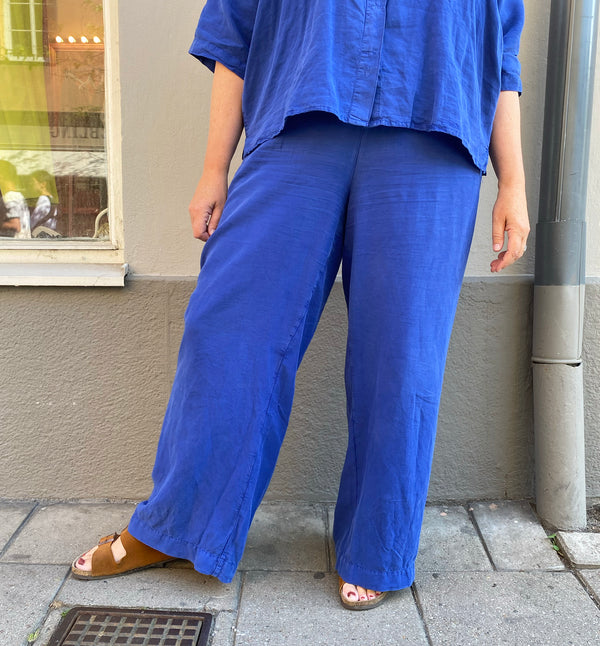 Byxor Thit från danska Muse Wear. Klassiska och bekväma byxor med resår i midja och vida, raka ben. Sydda i en lyxig Tencel- och linneblandning. Designad i danska Thy.&nbsp;

Färg: Royal blå

Material: 70% Tencel,&nbsp;30% linne.&nbsp;Detta tyg är tillverkat i Portugal.

Skötselråd: 30 grader fintvätt

Tillverkad i: Portugal&nbsp;