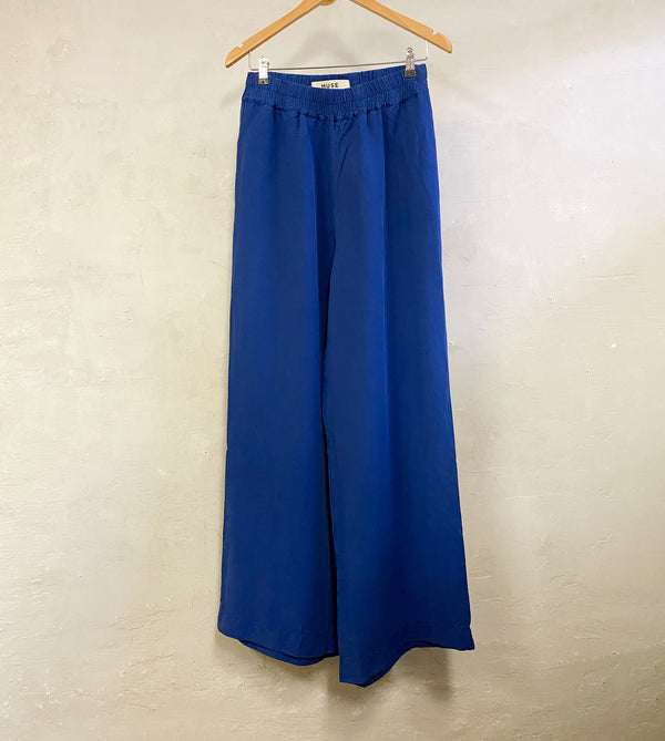Byxor Thit från danska Muse Wear. Klassiska och bekväma byxor med resår i midja och vida, raka ben. Sydda i en lyxig Tencel- och linneblandning. Designad i danska Thy.&nbsp;

Färg: Royal blå

Material: 70% Tencel,&nbsp;30% linne.&nbsp;Detta tyg är tillverkat i Portugal.

Skötselråd: 30 grader fintvätt

Tillverkad i: Portugal&nbsp;