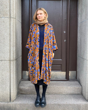 Lieblings kimono Gro i tyget Tosca. En lång lyxig kimono med fina kragdetaljer. Band att knyta i midjan. I kollektion Ridå har vi gjort Gro lite kortare än tidigare och i två storlekar. Tidigare onesize är nu S/M.&nbsp;

Färg: Mönster i kornblått, svart och beige på nougatbrun botten.

Material: 51% EcoVero, 49% viskos från Frankrike.