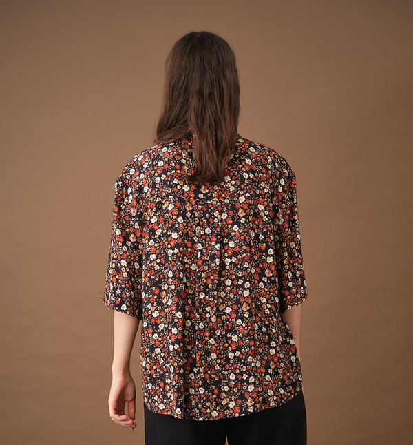 Lieblings skjorta Unni. Unni är en vid skjorta med armbågslång ärm. Ok med veck i ryggen. Lätt rundad bak. Sydd i en ekologisk viskos.

Färg: Små blommor i beige, vitt och orange på svart botten. Svart band.

Material:&nbsp;51% EcoVero, 49% viskos från Frankrike.