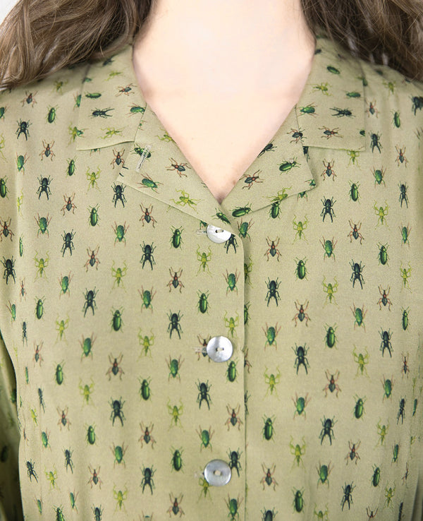 Klänning Arlom från Bric-a-brac! Krage, armbågslånga ärmar med smal manschett. Knappöppning till midjan. A-formad kjol med sneda sidofickor. Band i midjan. Pärlemorknappar.&nbsp;

Färg: Ljusgrön med skalbaggar i grönt, svart och rostrött

Material: 50% FSC EcoVero, 50% Rayon FSC EcoVero.

Skötselråd: 30 grader fintvätt. Strykes efter tvätt. 2% i längd.

Tillverkad i:&nbsp;Litauen