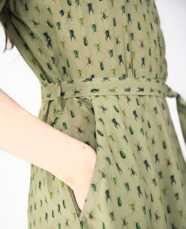 Klänning Arlom från Bric-a-brac! Krage, armbågslånga ärmar med smal manschett. Knappöppning till midjan. A-formad kjol med sneda sidofickor. Band i midjan. Pärlemorknappar.&nbsp;

Färg: Ljusgrön med skalbaggar i grönt, svart och rostrött

Material: 50% FSC EcoVero, 50% Rayon FSC EcoVero.

Skötselråd: 30 grader fintvätt. Strykes efter tvätt. 2% i längd.

Tillverkad i:&nbsp;Litauen