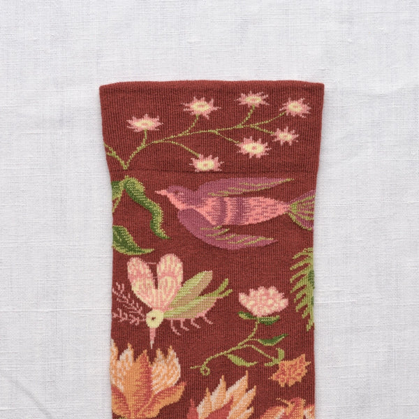 Strumpor från franska Bonne Maison. De är tillverkade av finaste egyptiska bomull och en dubbeltrådig elastan.&nbsp;

Färg: Växter och fåglar i grönt, rosa, aprikos på portvinsröd botten och grönbrun tå.&nbsp;

Material: 90% bomull, 8% polyamid, 2% elastan

Skötselråd: 30/40 grader

Tillverkad i: Portugal