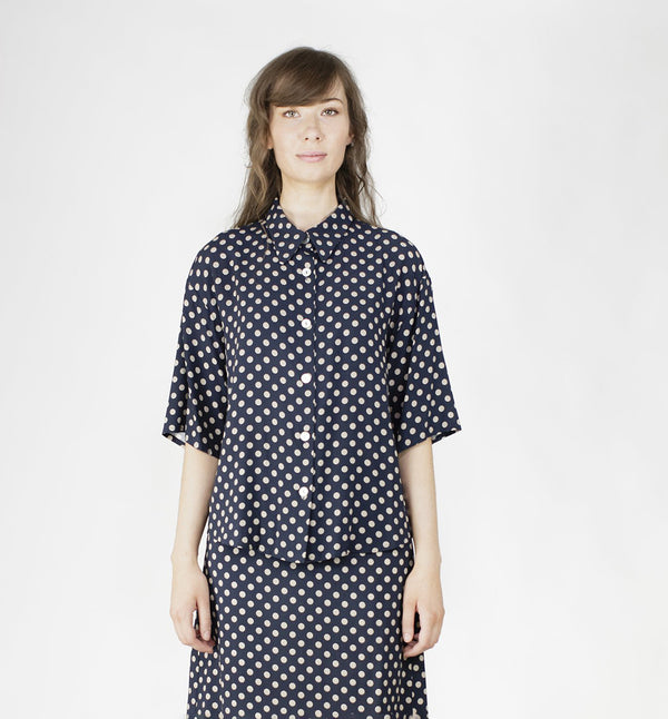 Blus Helgum från Bric-a-brac. Krage, armbågslång ärm, pärlemorknappar fram.&nbsp;

Färg: Vita prickar på mörkblå botten

Material: 100% FSC EcoVero.

Skötselråd: 30 grader fintvätt. Strykes efter tvätt. 2% i längd.

Tillverkad i:&nbsp;Litauen