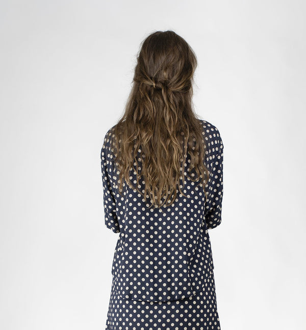 Blus Helgum från Bric-a-brac. Krage, armbågslång ärm, pärlemorknappar fram.&nbsp;

Färg: Vita prickar på mörkblå botten

Material: 100% FSC EcoVero.

Skötselråd: 30 grader fintvätt. Strykes efter tvätt. 2% i längd.

Tillverkad i:&nbsp;Litauen