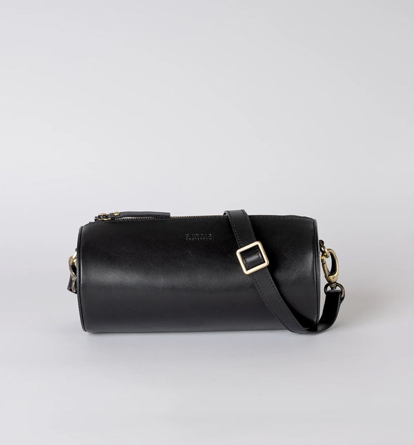 Handväska Izzy är O My Bag:s unika cylinderformade handväska som förkroppsligar den där edgy och retro, men ändå minimalistiska stilen. Denna cross-body-väska är tillverkad av hållbart ekologiskt läder. Izzys eleganta och moderna design gör att den passar lika bra till vardag som till fest. Den justerbara remmen gör att den kan bäras på olika sätt, som en cross-body-väska eller kortare för ett elegant axelalternativ. Svart läder. 